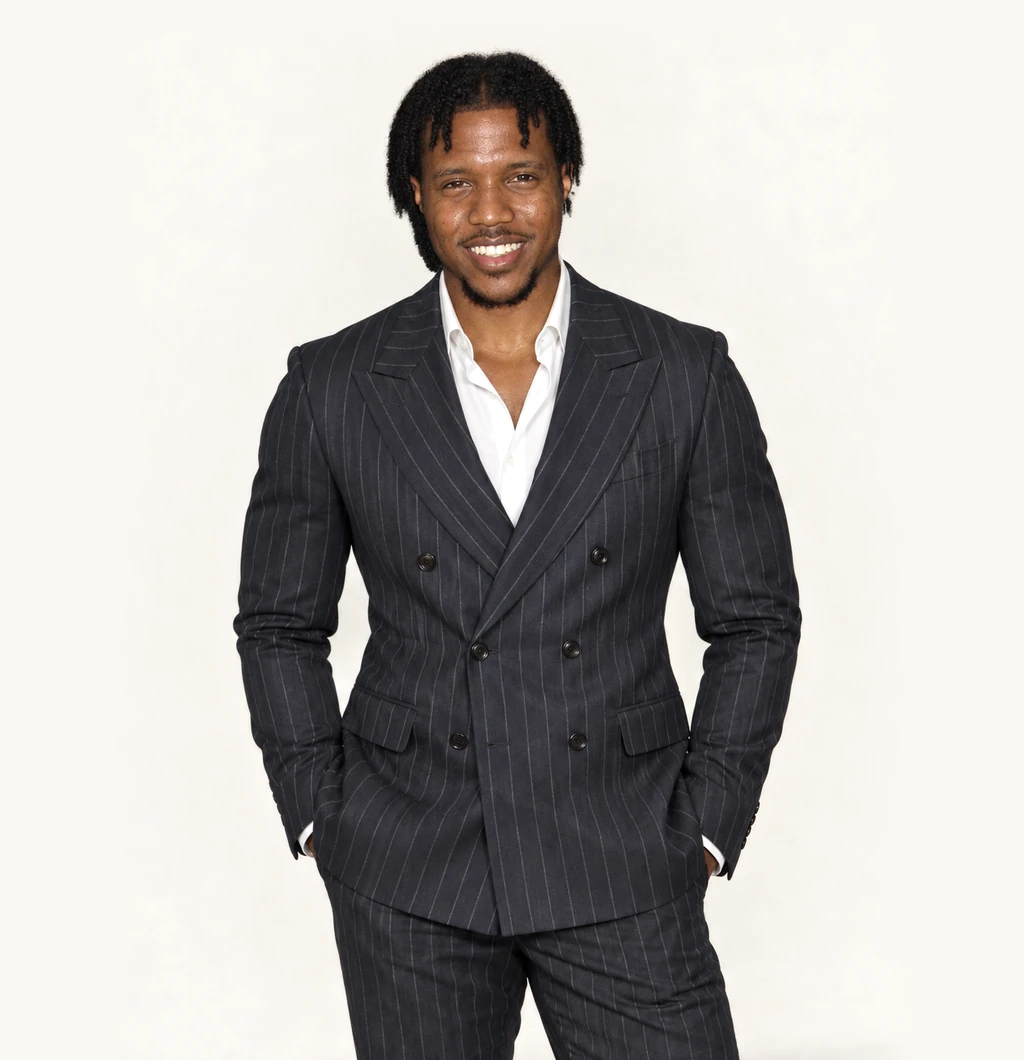 LaDonte Prince, standing, hands in his pockets, smiling.